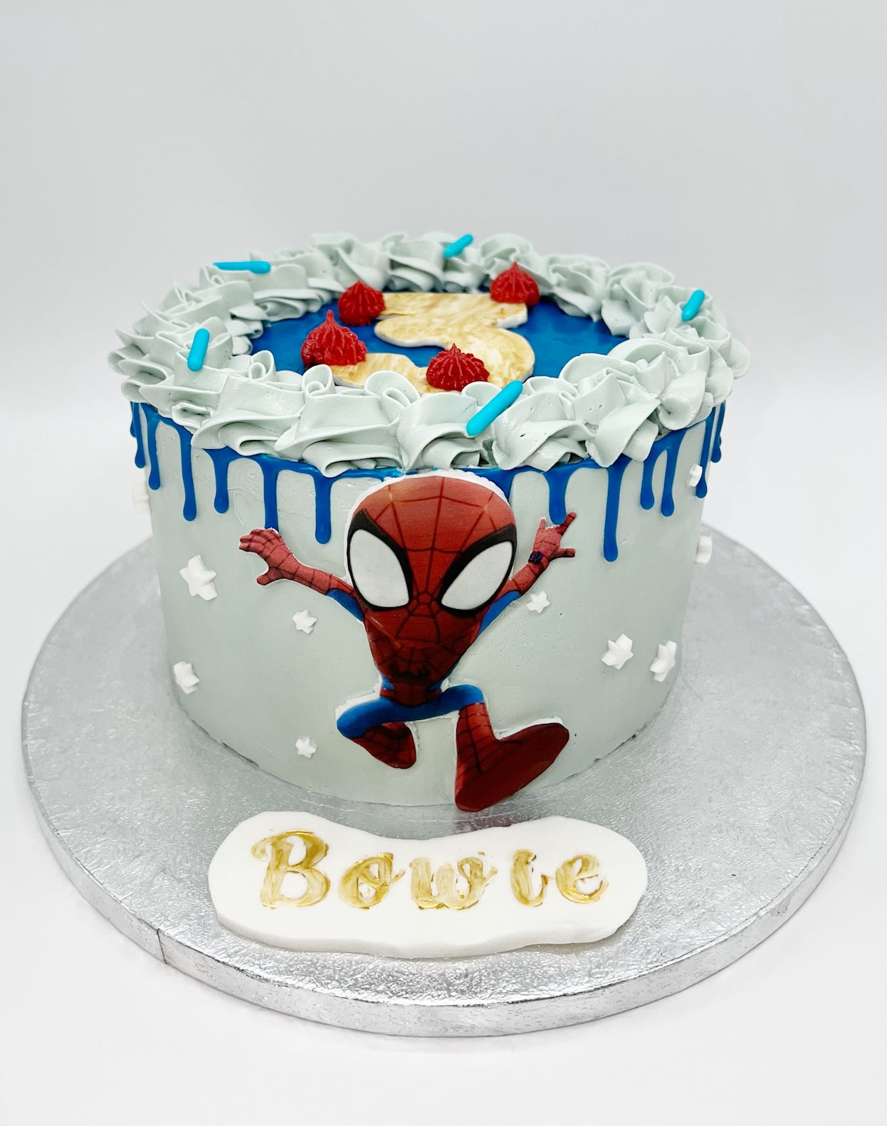 Barnkalastårta med Spiderman-dekor och namntexten Bowie, dekorerad med blå drip och stjärnor – Ganache Cakery Malmö.

Children’s birthday cake with Spiderman design and name ‘Bowie’, decorated with blue drip and stars – Ganache Cakery Malmö.

Gâteau d’anniversaire pour enfant avec décor Spiderman et prénom ‘Bowie’, décoré de drip bleu et d’étoiles – Ganache Cakery Malmö.